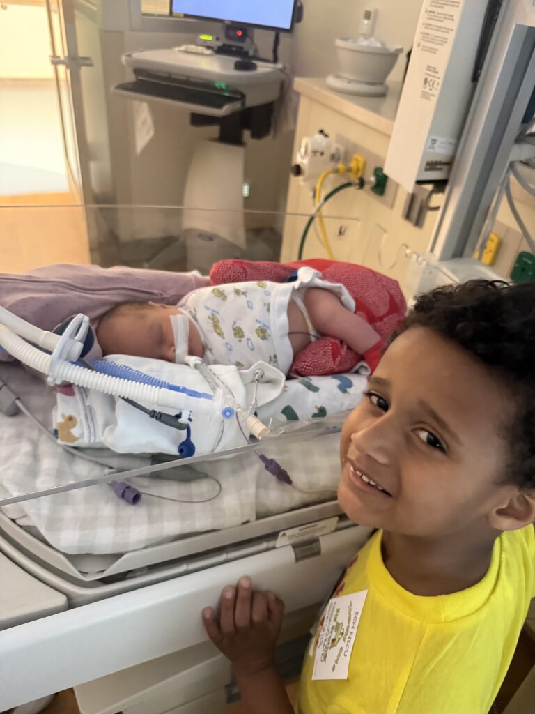 Jakob McMillan visits his baby sister Joslyn in the NICU
