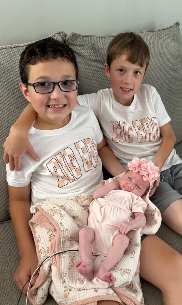Carter and Colton Stephens sit with their baby sister Sophie